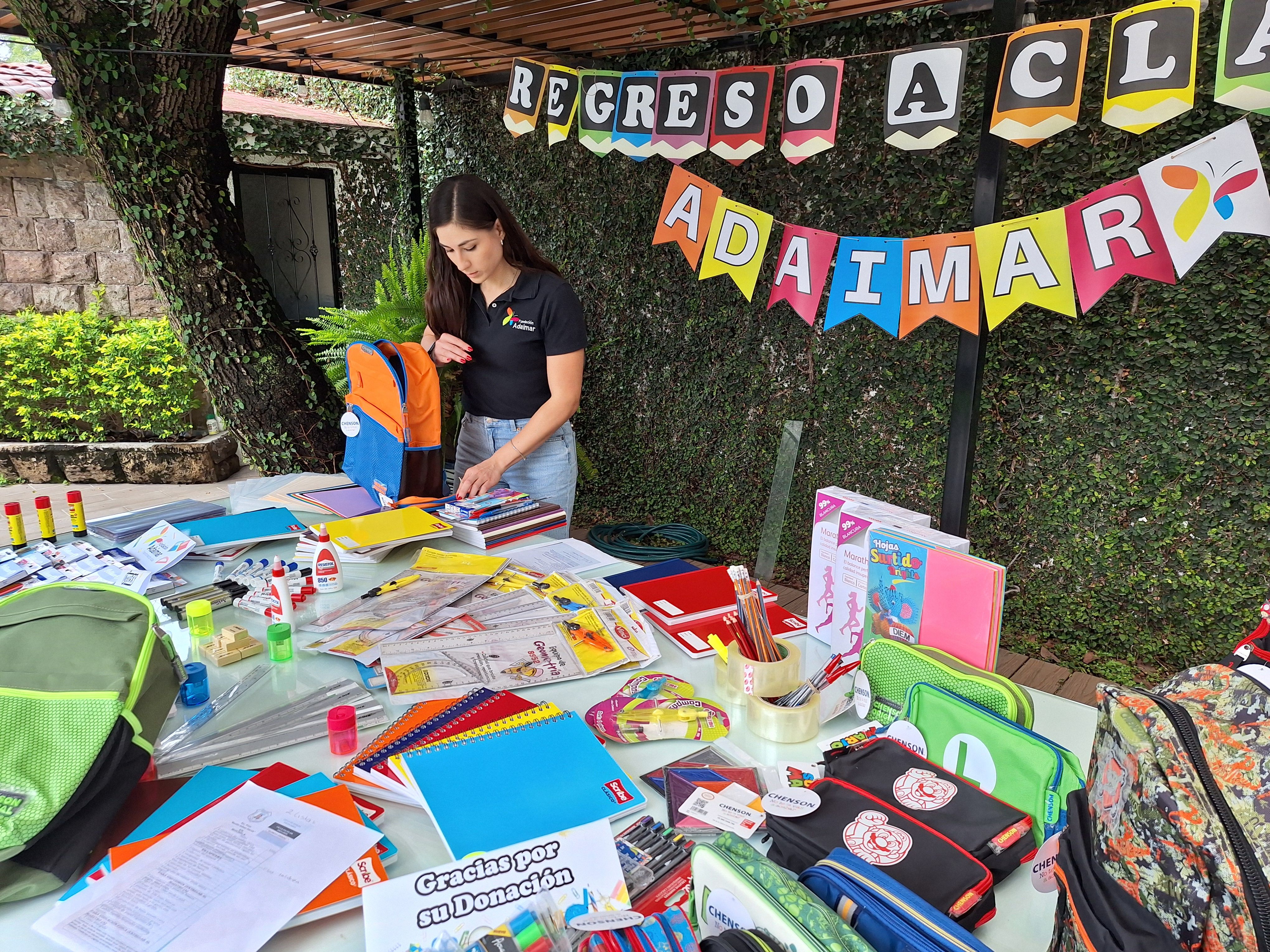 Voluntaria organizando útiles escolares en evento Regreso a Clases de Adaimar
